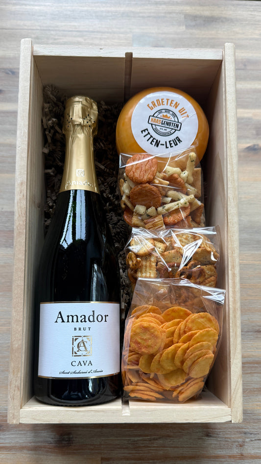 Houten wijnkist met fles cava, kaas en zoutjes/nootjes