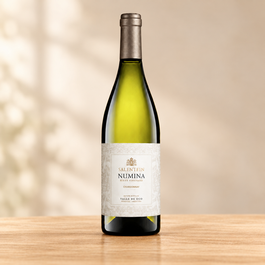 Fles Salentein Numina Chardonnay 2024 op een lichte, warme houten ondergrond