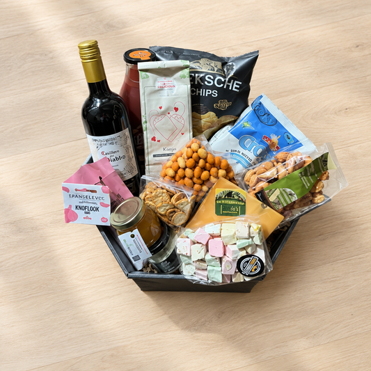 Cadeaupakket bij de open haard met dezelfde inhoud en opstelling op een lichte houten ondergrond